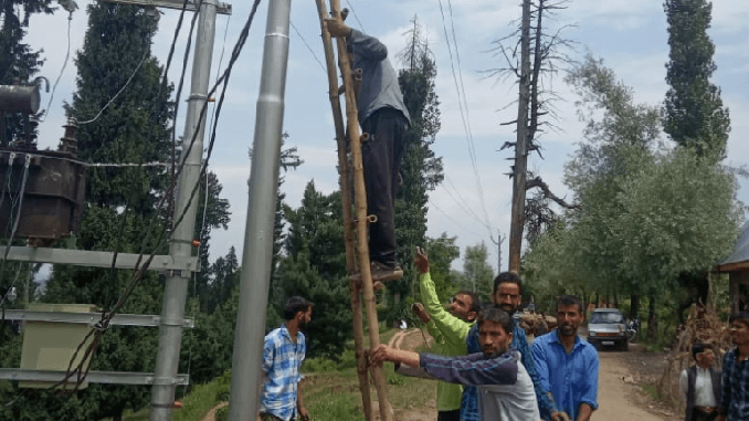 Local people help PDD employees while working on the transmission line